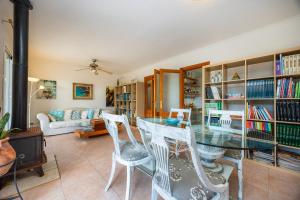 ein Esszimmer mit einem Glastisch und weißen Stühlen in der Unterkunft Casa del Lago in Port d'Alcúdia