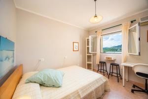 ein Schlafzimmer mit Bett, Schreibtisch und Fenster in der Unterkunft Casa del Lago in Port d'Alcúdia