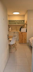 a kitchen with a table and a white chair at GoldSea - Boutique Seafront Studio in Nahariyya
