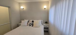 a bedroom with a bed with white sheets and pillows at GoldSea - Boutique Seafront Studio in Nahariyya +22 photos