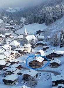 un pueblo cubierto de nieve con una iglesia en CHALET CHARMING BED and BREAKFAST, en Les Gets