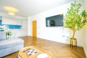 a living room with a couch and a potted tree at Highfields House Spinny Hill Northampton in Spinney Hill +5 photos