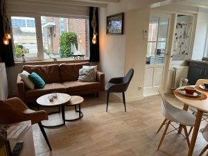 una sala de estar con un sofá y una mesa en Familiehuis Castor 300 m van het strand, en Noordwijk aan Zee