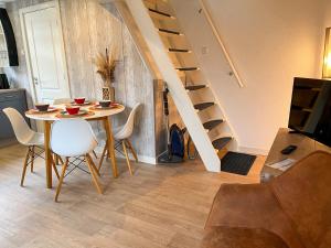 Un comedor con mesa y sillas y una escalera. en Familiehuis Castor 300 m van het strand, en Noordwijk aan Zee 13 fotos más