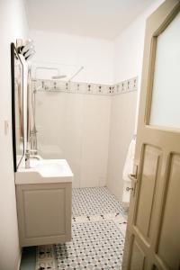 a white bathroom with a sink and a shower at Nostalgia in Turda