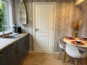 Una cocina con una mesa y una puerta blanca. en Familiehuis Castor 300 m van het strand, en Noordwijk aan Zee