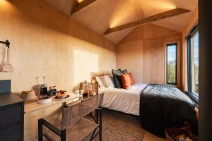 a bedroom with a bed in a room with a table at Cabins at Bogee Farm in Saint Ervan