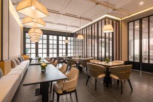 ein Restaurant mit Tischen und Stühlen und Fenstern in der Unterkunft SDADSBESÖK Dragon Pearl Hotel (Yibin Guanying Ancient Street Hejiangmen Plaza Branch) in Nanguang