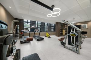 einen Fitnessraum mit mehreren Laufbändern und Kardiogeräten in der Unterkunft SDADSBESÖK Dragon Pearl Hotel (Yibin Guanying Ancient Street Hejiangmen Plaza Branch) in Nanguang