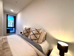 a bedroom with a bed with pillows and a window at Mcity Clayton Urban 2BR with Stunning View in Clayton North +2 photos