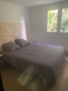 a bedroom with a bed with a wooden headboard and a window at Chez Nico in Frans