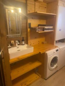 a bathroom with a sink and a washing machine at Chez Nico in Frans