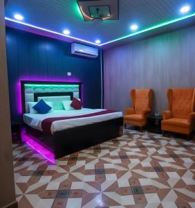 a bedroom with a bed and two orange chairs at TRIP MY BUDDY Hotels in Varanasi