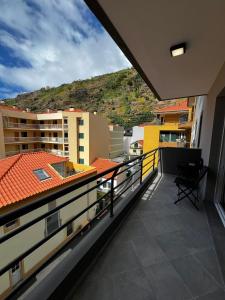 un balcone con vista sugli edifici e sulla montagna di Island Heart- Family Retreat- Free parking garage a Ribeira Brava