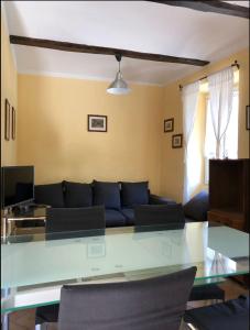 a living room with a blue couch and a glass table at Cascina Bolichin appartamento Mentha in Rodello