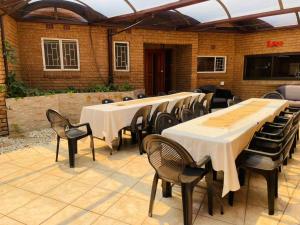 a group of tables and chairs in a patio at Vaal Triangle Guest House in Vanderbijlpark