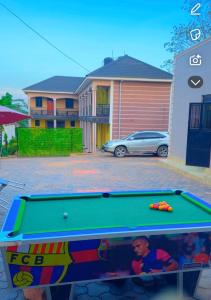 a pool table in front of a house at Shamo Inn And Lounge Mukono in Mukono