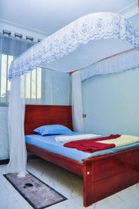 a bed with a canopy in a room at Shamo Inn And Lounge Mukono in Mukono
