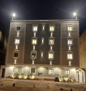 a large building with many windows at night at a 6 استيديو راقي في ملقا in Quai