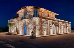 a large stone building with a blue door at night at Masseria Finigrini Luxury in Corato