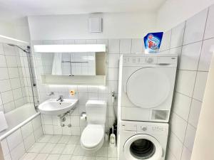 un bagno con lavatrice e lavandino di WA - Penthouse 6 Pax City Apartment Zürich a Zurigo Altre 22 foto