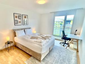 una camera da letto con un letto, una scrivania e una finestra di WA - Penthouse 6 Pax City Apartment Zürich a Zurigo