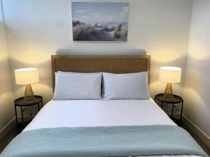 a bedroom with a bed with two lamps on both sides at MERCER APARMENTS 2 Bedroom Apartment with Bay Views on the Geelong Waterfront - 609 in Geelong