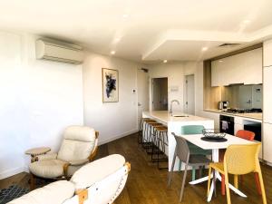 a kitchen and a living room with a table and chairs at MERCER APARMENTS 2 Bedroom Apartment with Bay Views on the Geelong Waterfront - 609 in Geelong