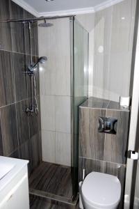 um banheiro com chuveiro, vaso sanitário e pia em Rachoni Resort em Skala Rachoniou