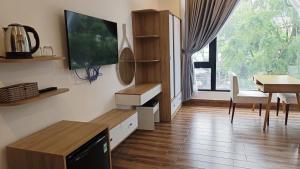 a living room with a tv and a table and a tableablish at ROMANCE HOTEL DALAT in Da Lat