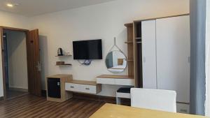 a room with a tv and a table and a mirror at ROMANCE HOTEL DALAT in Da Lat +8 photos