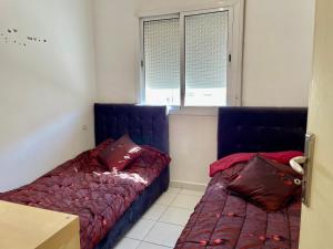 a bedroom with two beds and a window at luxury apartment in fez in Oulad Akkou