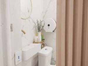 a white bathroom with a toilet and a sink at Pierside Inn in Cebu City