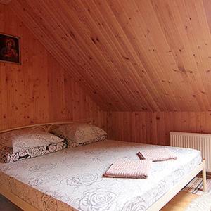 a bedroom with a bed in a wooden ceiling at Вікторія Ретрит центр in Zhukovtsy +29 photos