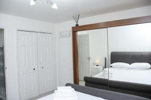 ein Schlafzimmer mit großem Spiegel und Bett in der Unterkunft Peterborough Haven: 3BD Family Home Retreat in Peterborough + 26 Fotos