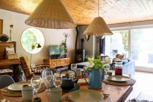 a dining room with a table with plates and glasses at Stilbjerg Sleep&Hygge in Varde