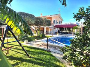 a yard with a pool and a house at Villa Mónica in Orihuela