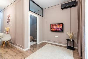 a living room with a window and a tv on the wall at Квартира в ЖК бизнес класса in Almaty