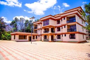 ThikaSunstar Resort Thika的前面有砖瓦车道的大建筑