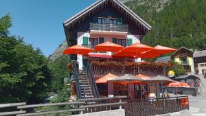 un bâtiment avec des parasols orange devant lui dans l'établissement Hôtel Le Mont Jorat, à Abondance