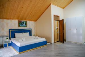 a bedroom with a blue and white bed with a wooden ceiling at Qusar Boutique in Qusar +18 photos