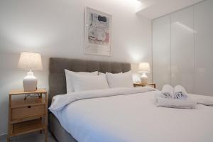a bedroom with a large white bed with two lamps at Koukaki Urban Suites in Athens