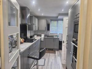a kitchen with stainless steel appliances and a stove at Sleeps 5 - Free Parking - Near Airport & City in Wythenshawe