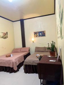 a room with two beds and a table at Subangan bayud3, Burgos central location in Burgos