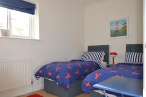 a bedroom with two beds and a window at Manor House Apartment 2 in Shaldon
