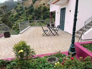 a balcony with chairs and a table on a house at Rose house in Ribeira Brava