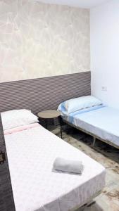 a room with two beds and a table in it at Casa Damais in Seville