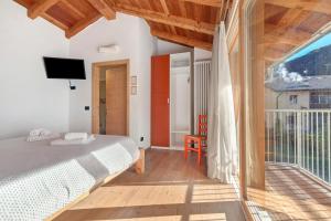 a bedroom with a bed and a balcony at Appartamento Saone in Ragoli