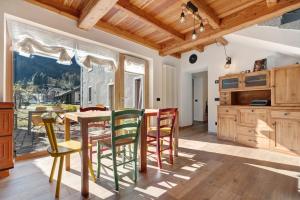 a kitchen with a table and chairs and a large window at Appartamento Saone in Ragoli