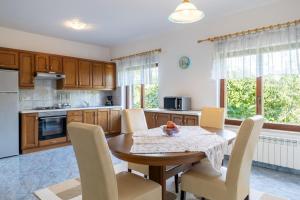 a kitchen with a wooden table and chairs in a room at Maria Buzet 1 with Shared Pool in Buzet
